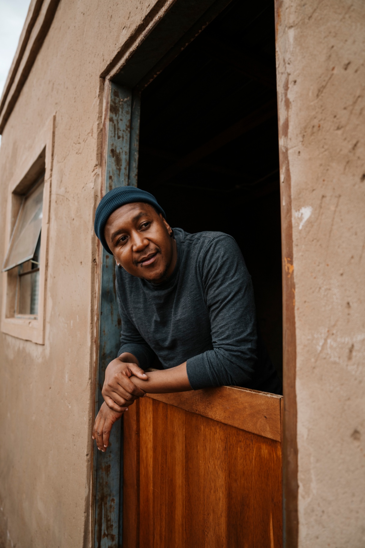 Resident leaning out of a half-door, smiling — connected at home