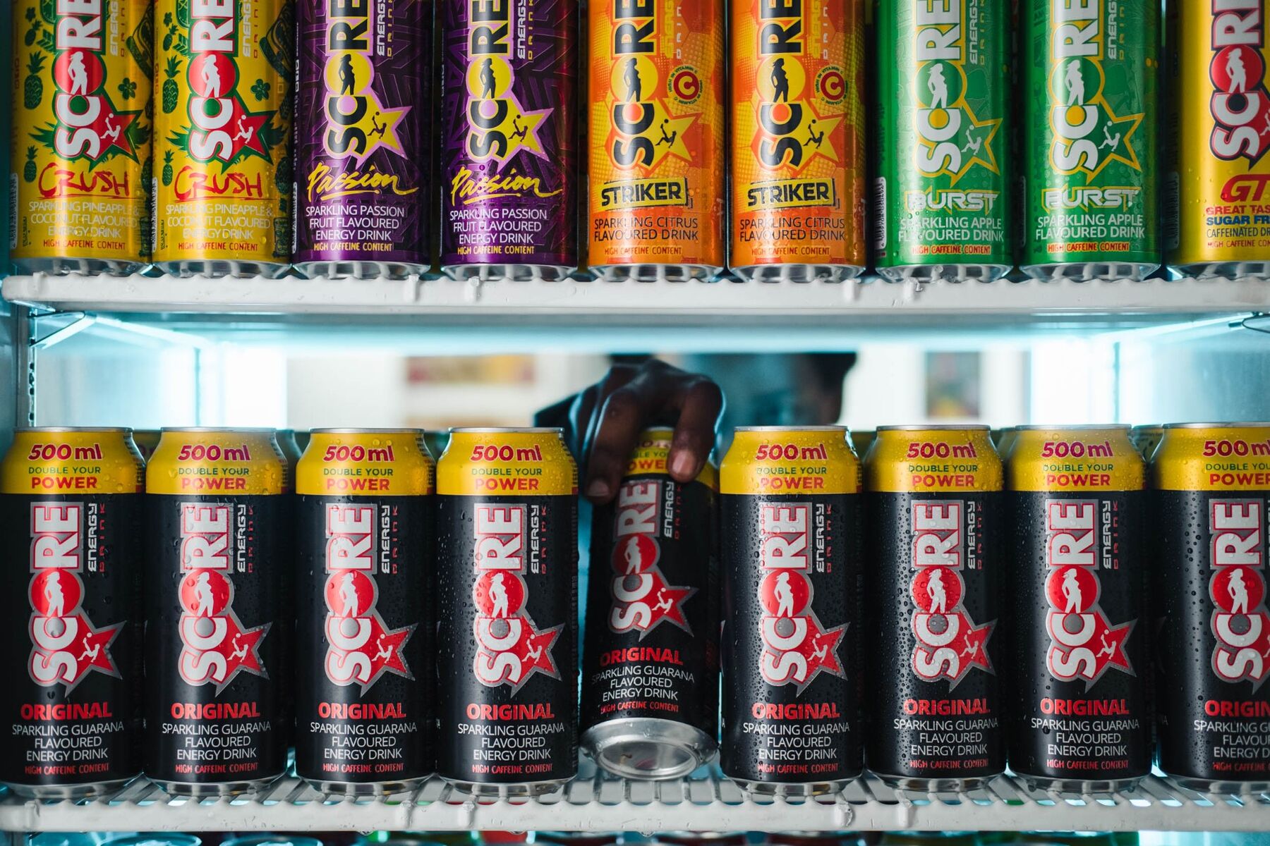 A fridge stacked with Score Energy cans across multiple flavours