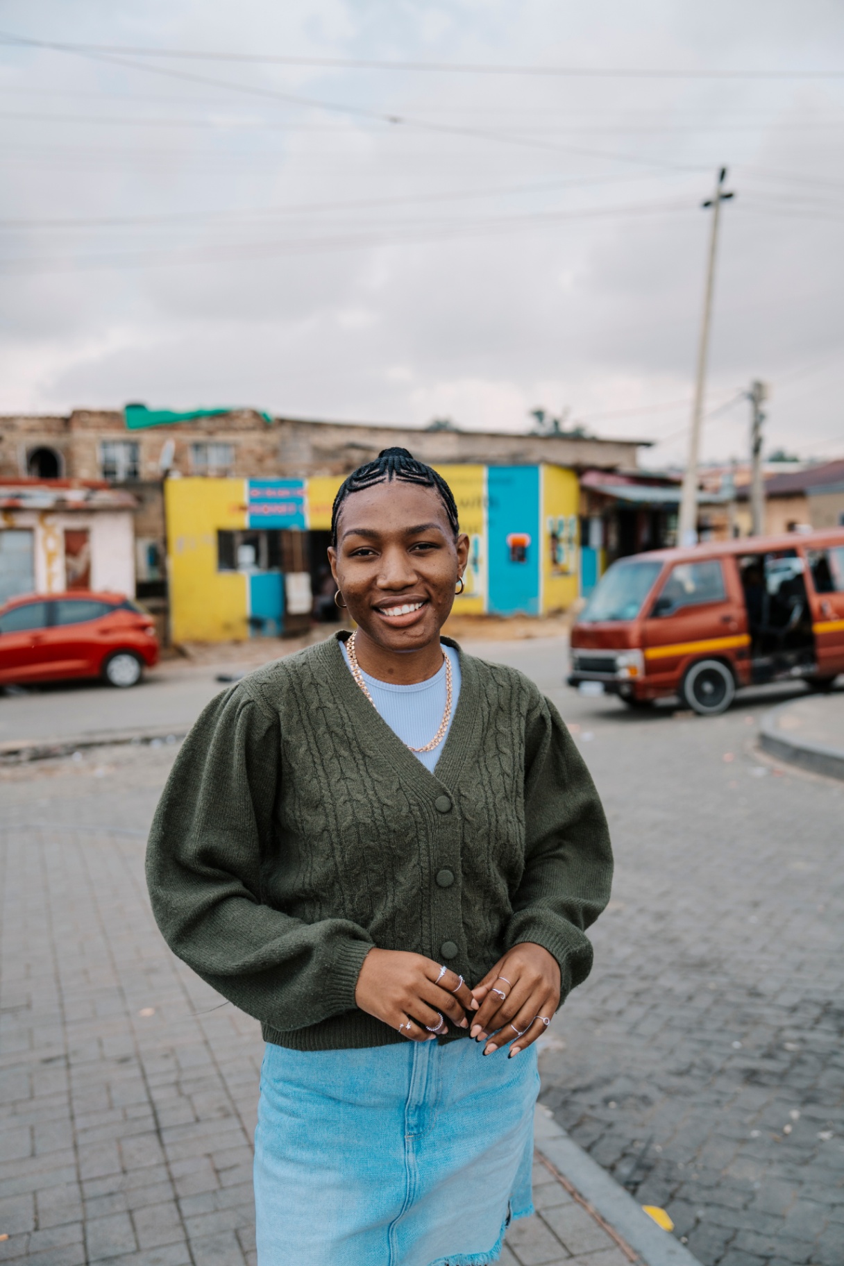 Young woman portrait on a township street, smiling to camera