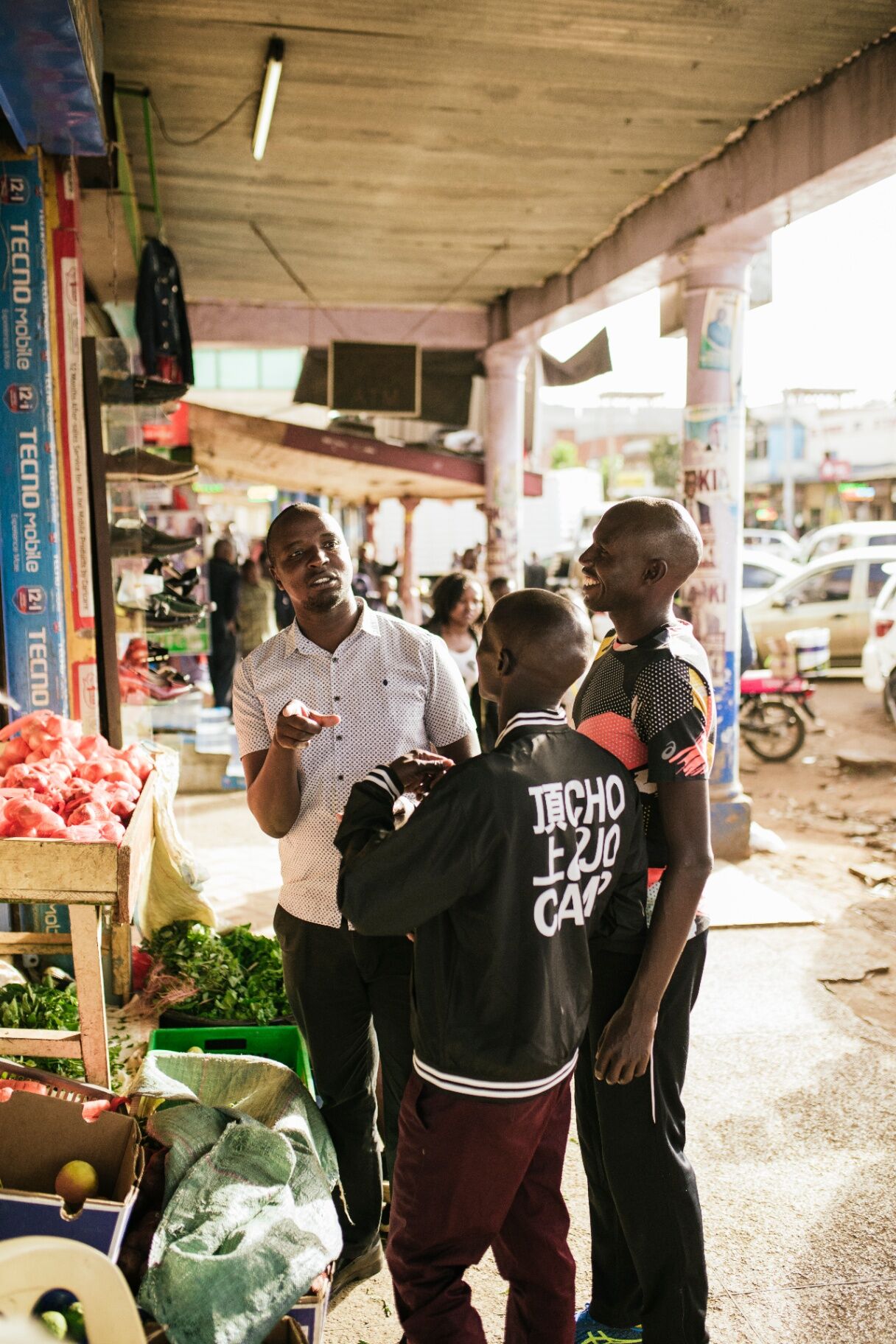 Camp athletes laughing with a local trader at a Kenyan market
