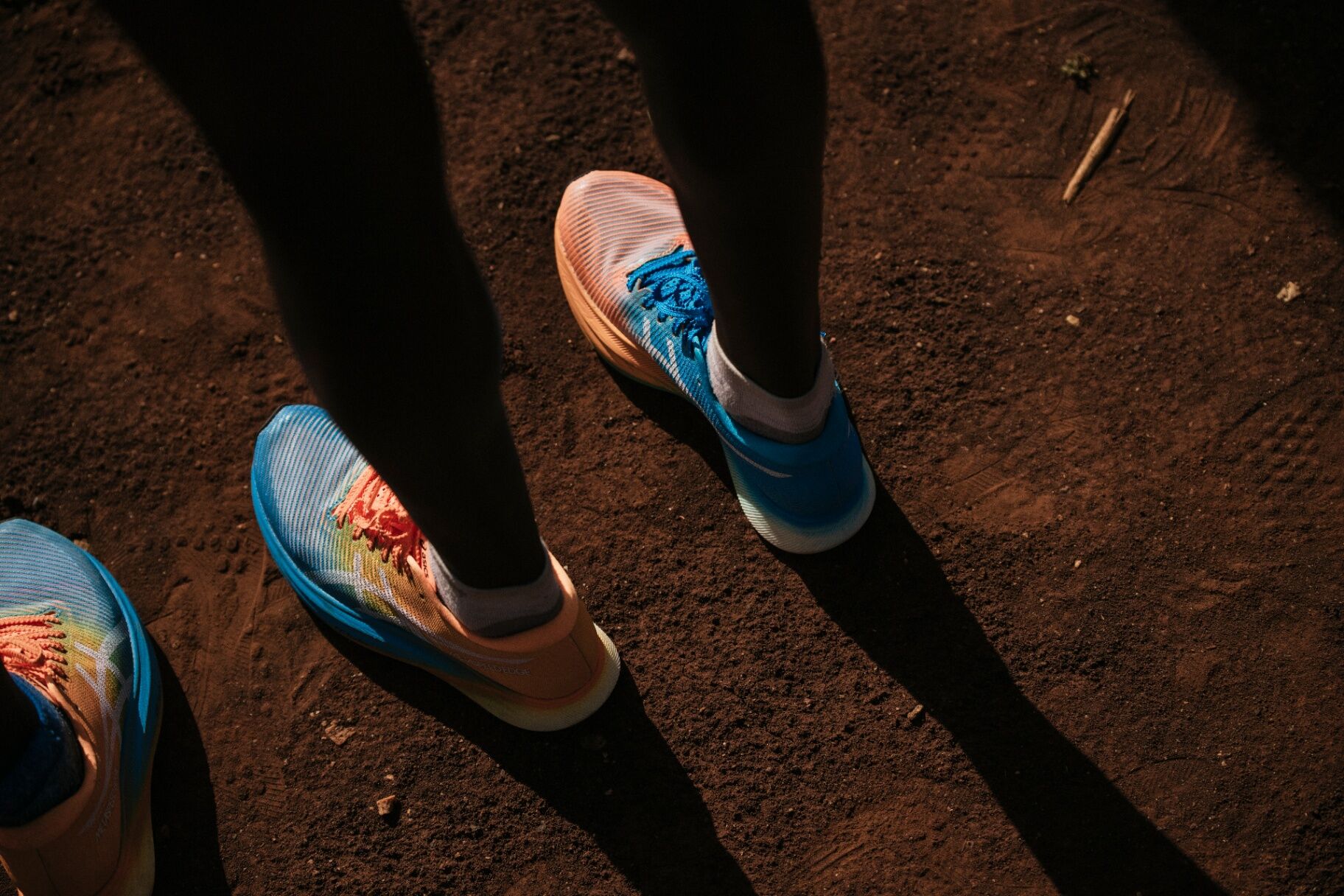 Close-up of an ASICS MetaSpeed Edge on red Kenyan dirt, side light