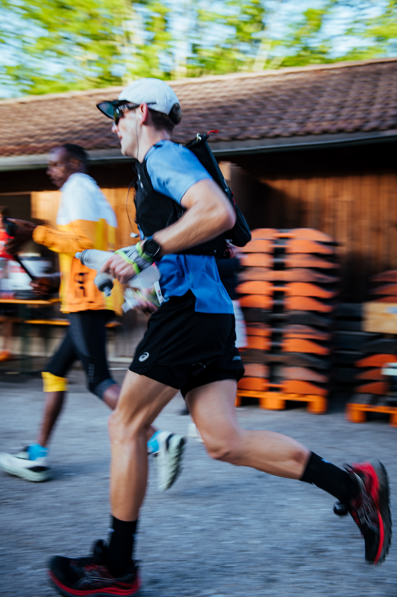 Side-on pan of a Mozart 100 runner moving past pallets at speed